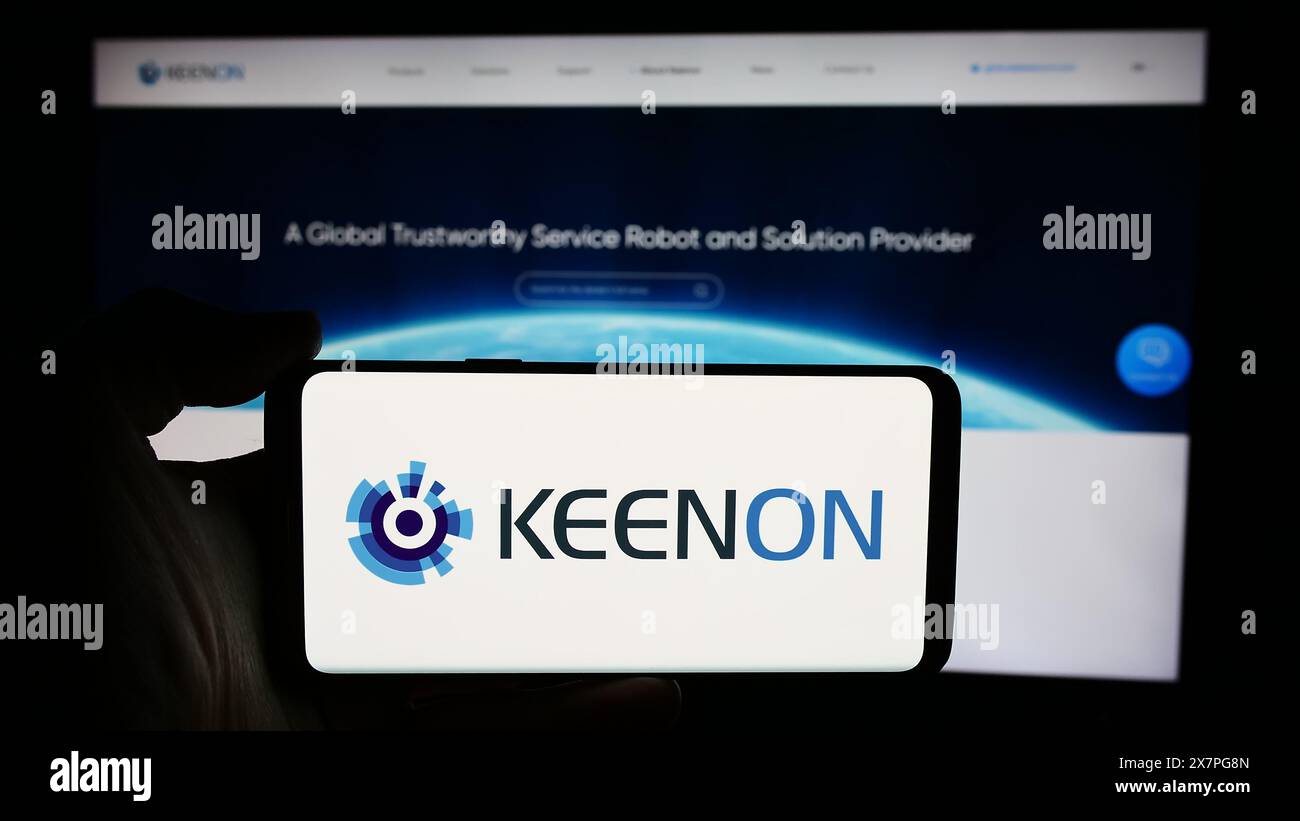Personne tenant le téléphone portable avec le logo de la société chinoise de robot de service Keenon Robotics Co. Ltd en face de la page Web. Concentrez-vous sur l'affichage du téléphone. Banque D'Images Personne tenant le téléphone portable avec le logo de la société chinoise de robot de service Keenon Robotics Co. Ltd en face de la page Web. Concentrez-vous sur l'affichage du téléphone. Banque D'Images