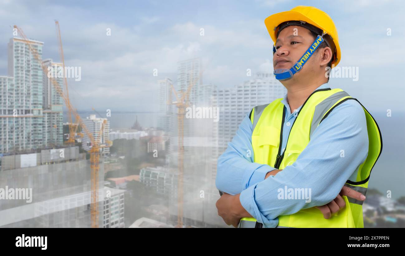 Architecte ingénieur civil debout tenant un casque de sécurité sur fond de chantier de construction, le chantier de construction prévoit de construire des bâtiments de grande hauteur, engin Banque D'Images