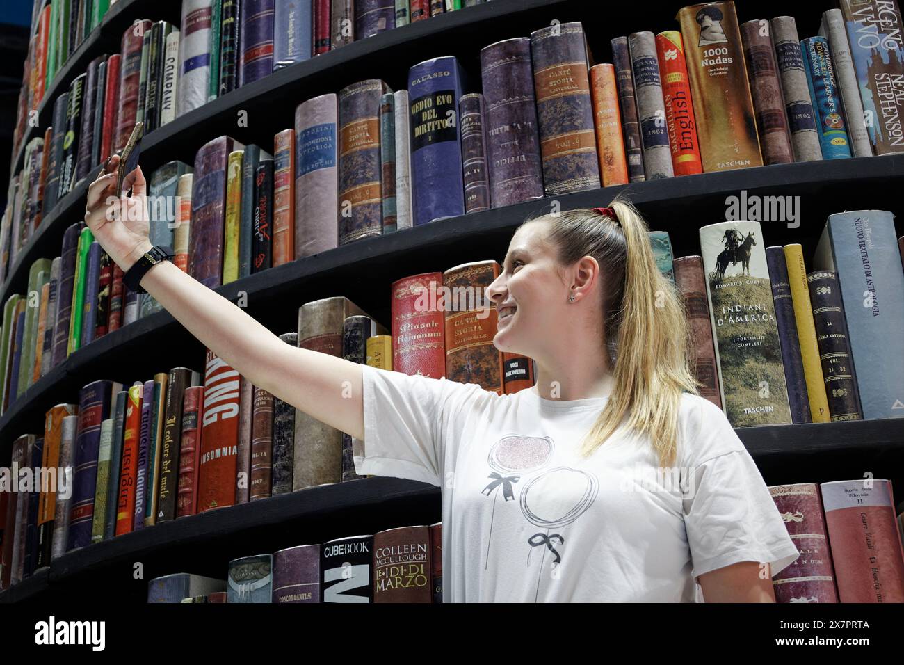 Une fille prend un autoportrait devant la tour des livres. Banque D'Images