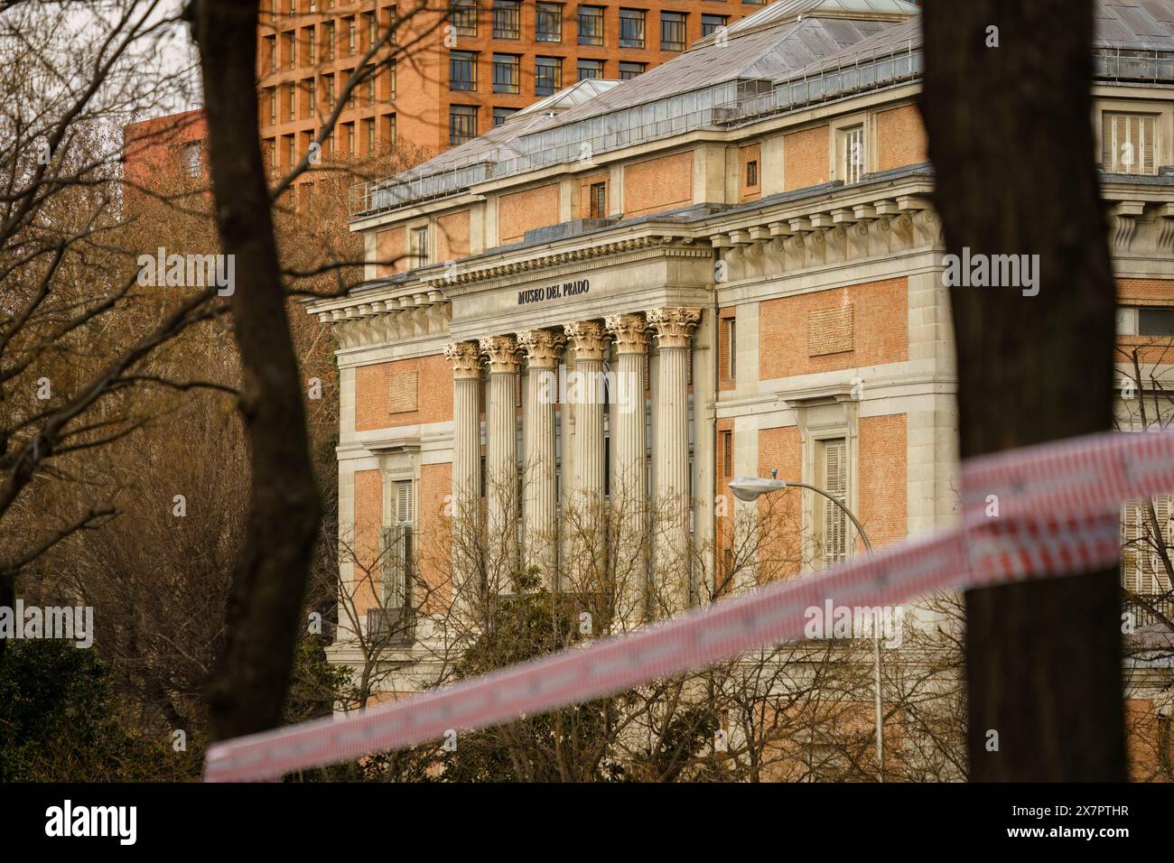 Madrid, Espagne. 12 février 2024 - Museo Del Prado avec du ruban d'avertissement rouge attaché aux arbres au premier plan. Banque D'Images