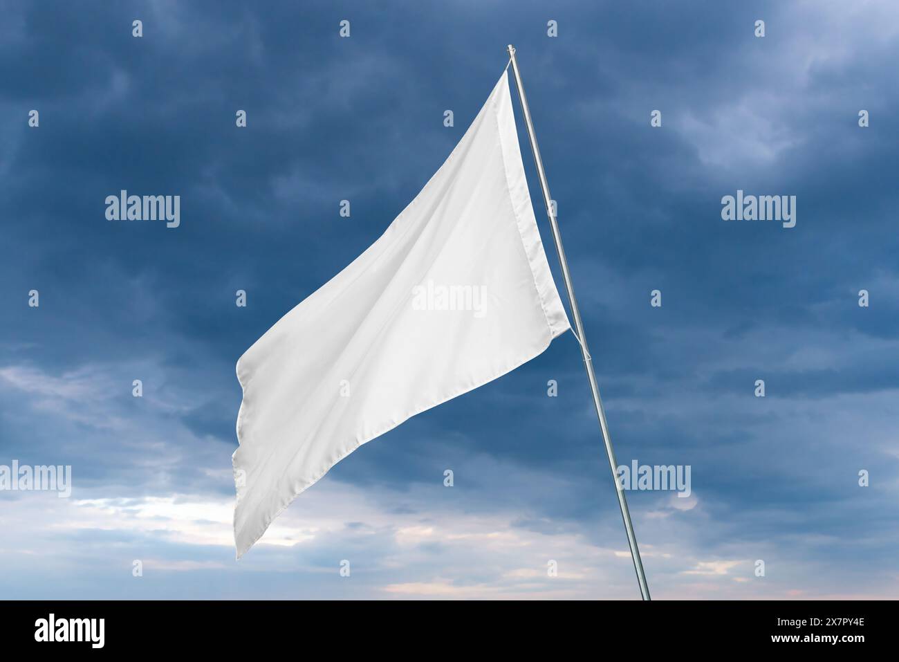 Un drapeau blanc ondule dans le vent avec des nuages sombres en arrière-plan, parfait pour l'état ou la maquette de drapeau publicitaire avec une texture propre Banque D'Images