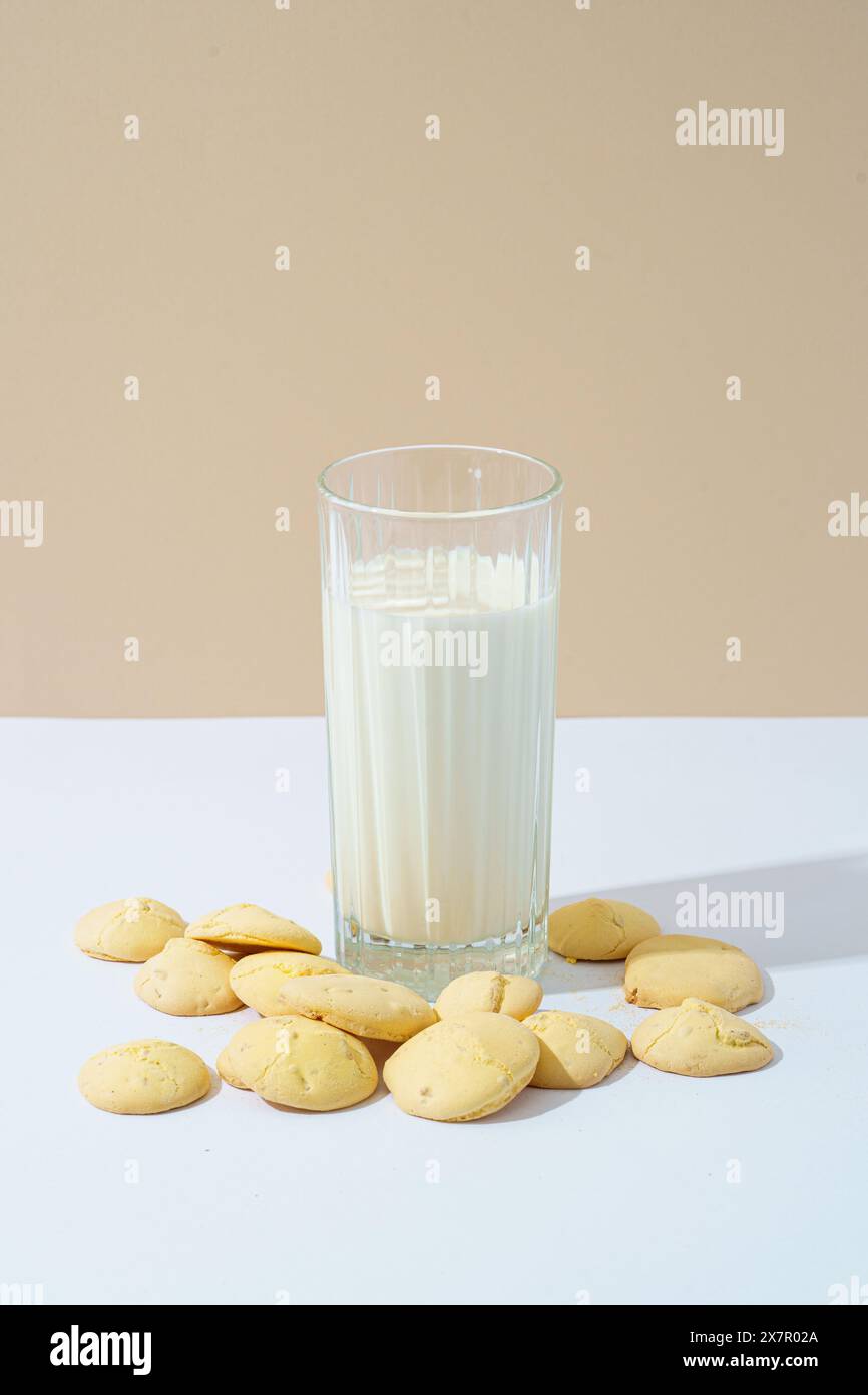 Une image chaleureuse et accueillante mettant en valeur des biscuits aux raisins secs faits maison accompagnés d'un verre rafraîchissant de lait froid, sur un fond neutre. Banque D'Images