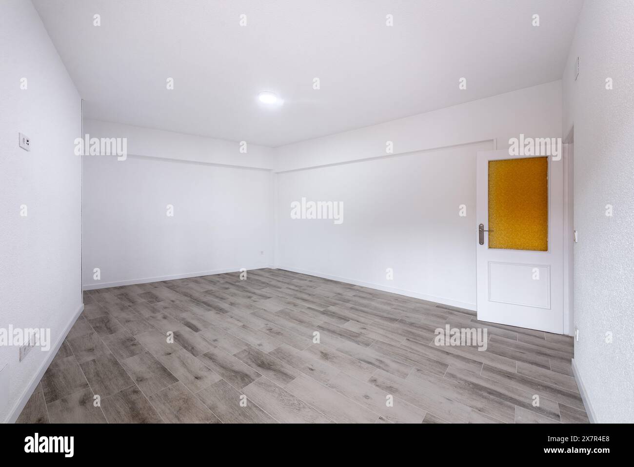 Capturez l'essence de la vie moderne avec cet intérieur d'appartement vide lumineux et expansif. Les murs blancs et le plancher en bois laminé Highligh Banque D'Images
