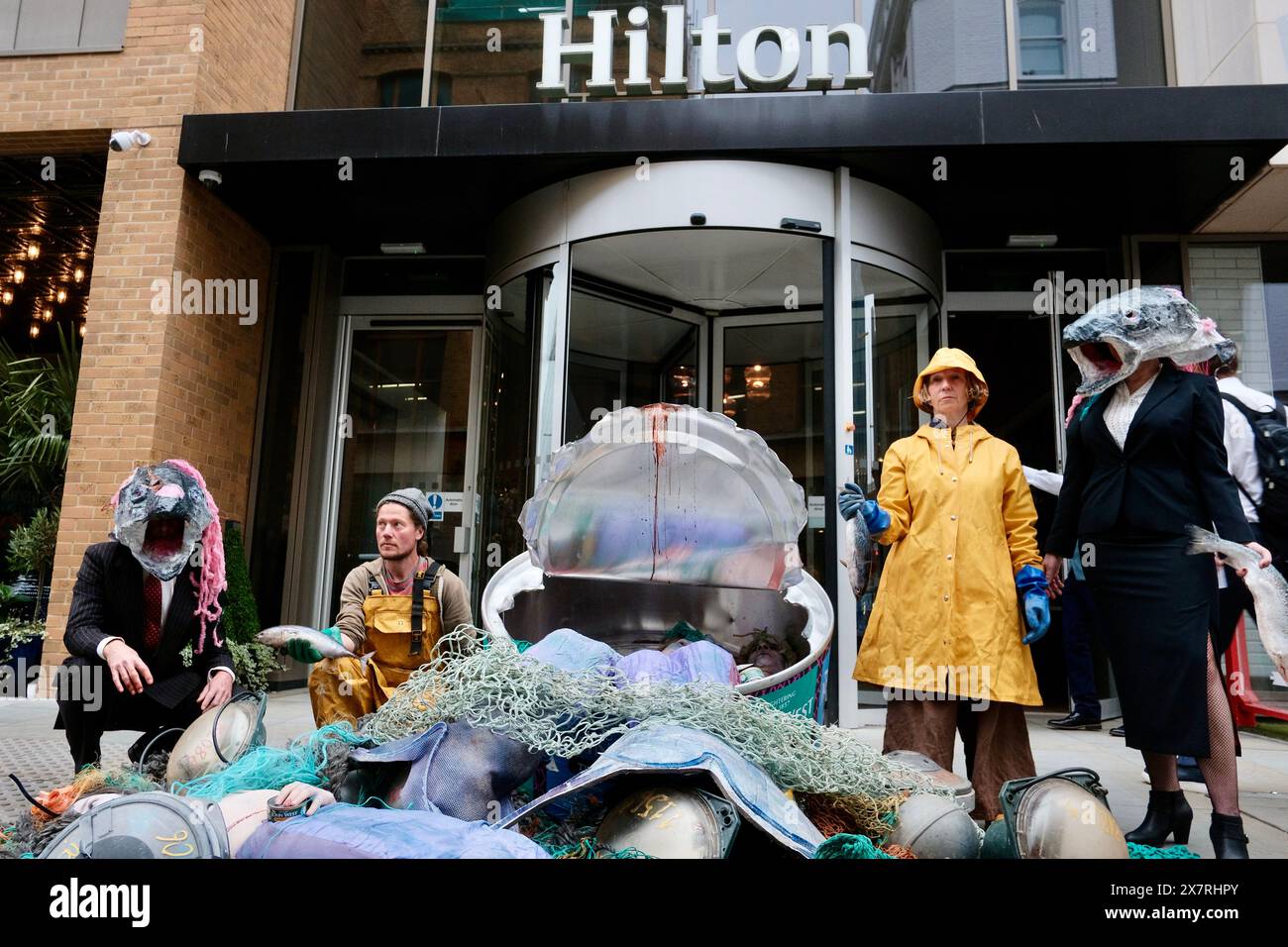 Ocean Rebellion, un groupe de militants écologistes, organise une protestation dramatique contre John West Tuna lors du Blue Food innovation Summit. Une boîte géante étiquetée «JOHN WEST, THONOT CHUMPS» est déchirée, révélant des «prises accessoires» de merveilles sanguinaires, symbolisant les victimes involontaires des pratiques de pêche industrielle. La manifestation met en lumière l'utilisation controversée de dispositifs d'agrégation de poissons dérivants (dFAD) par des pêcheries provenant de Thai Union, le propriétaire de John West. Les activistes critiquent le sommet pour son accent sur le « greenwash » de l’industrie de la pêche industrielle, plutôt que sur son impact sur le milieu marin Banque D'Images