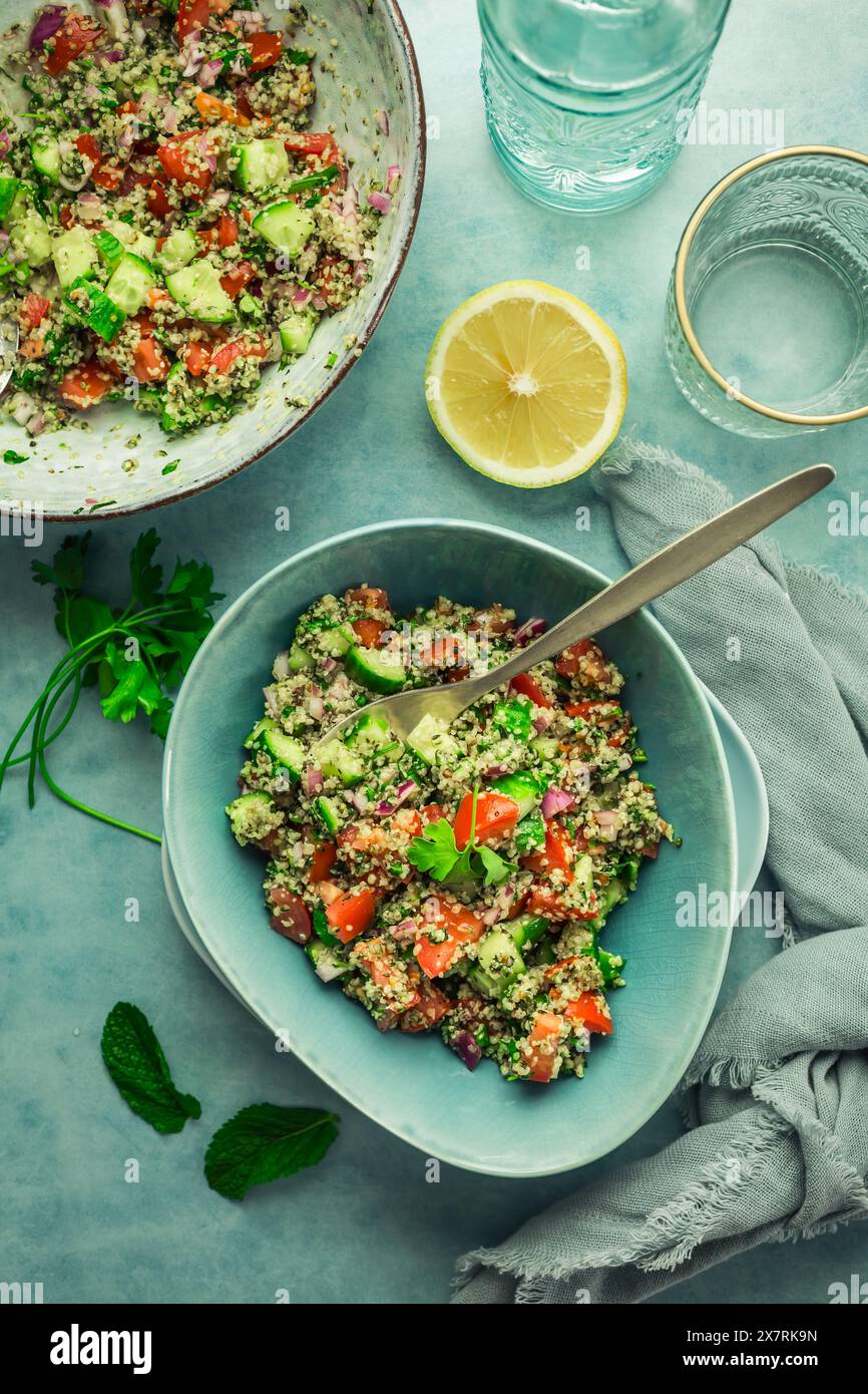 Salade de taboulé. Salade Tabouli maison fraîche avec persil frais, oignons, tomates et graines de chanvre. Banque D'Images