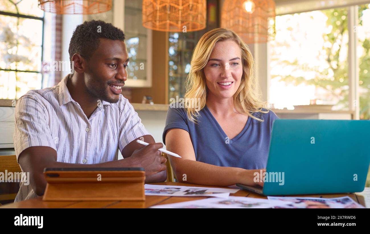 Couple travaillant à domicile dans l'édition de conception ou l'industrie créative avec tablette numérique avec stylet Banque D'Images