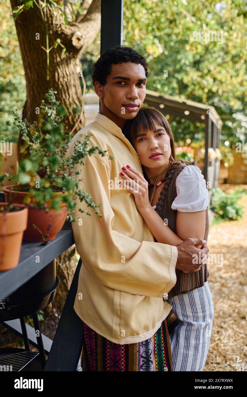 Un homme et une femme de races différentes se tiennent unis l'un à côté de l'autre, expérimentant l'amour et la compagnie dans un cadre naturel magnifique. Banque D'Images