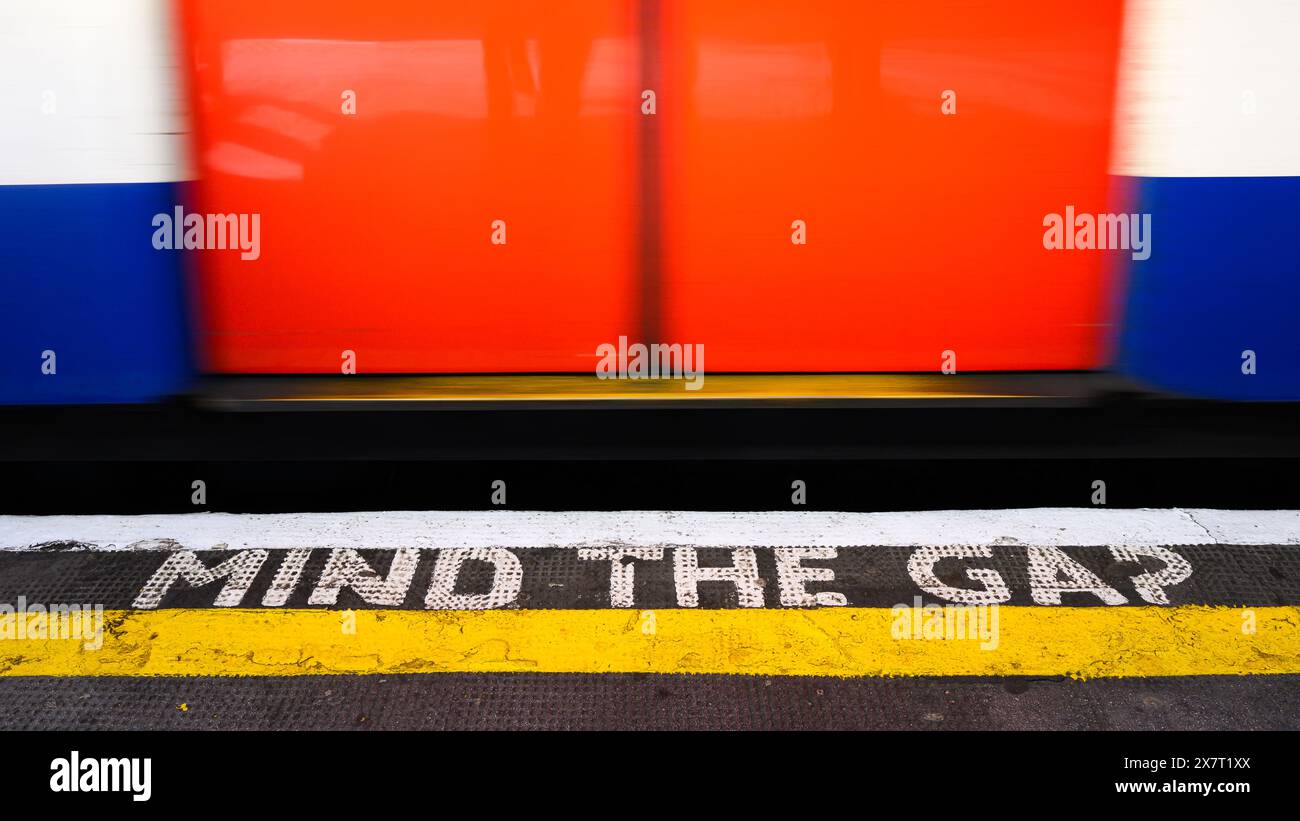 Londres, Royaume-Uni - 23 mars 2024 ; emblématique panneau d'avertissement London transport sur le métro pour tenir compte de l'écart entre le passage d'un train de métro flou et le bord du quai Banque D'Images