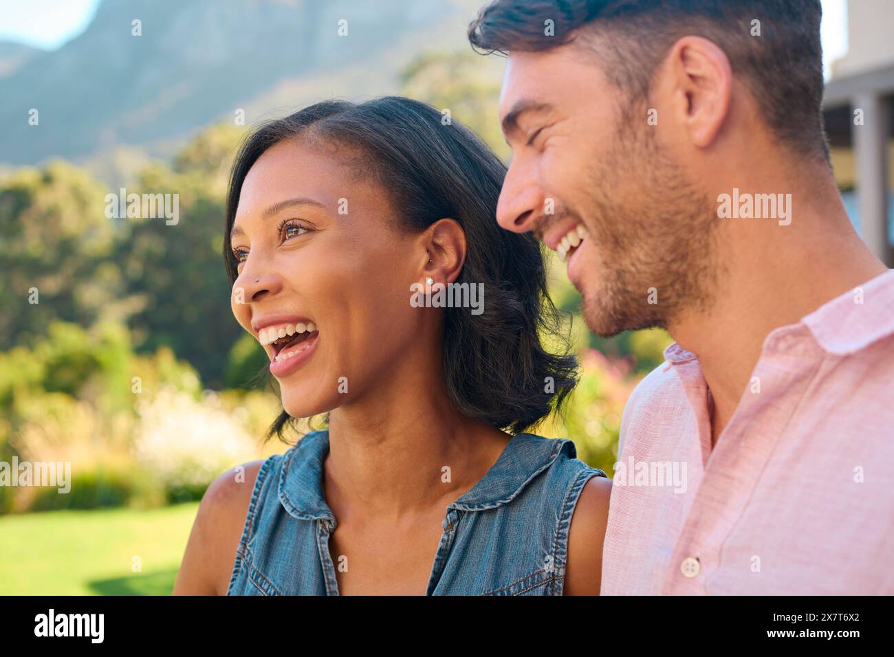 Portrait de rire et sourire couple multi-racial debout à l'extérieur dans la campagne Banque D'Images