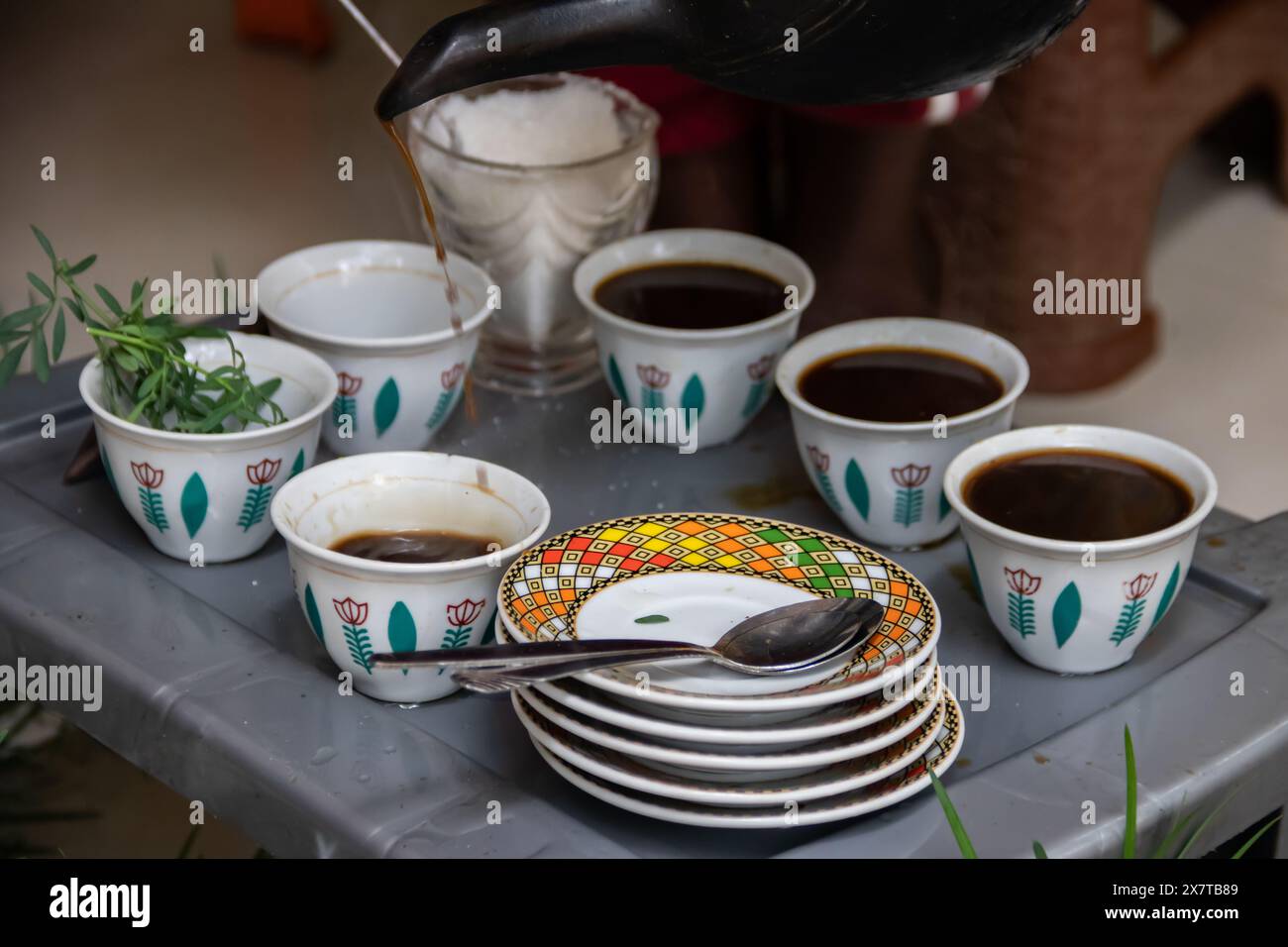 Des grains de café fraîchement torréfiés, un mortier et un pilon avec du jebena et de la fumée d'encens créent une configuration traditionnelle de cérémonie du café éthiopien Banque D'Images