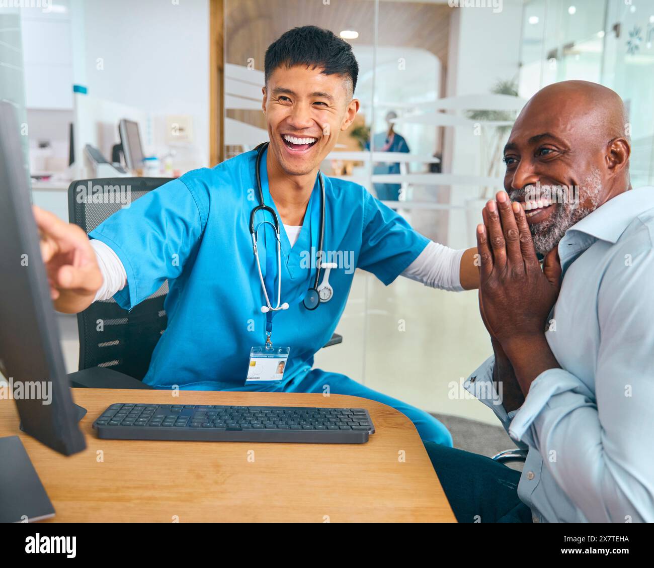 Médecin masculin portant des gommages au rendez-vous de l'hôpital donnant de bonnes nouvelles au patient masculin mature Banque D'Images