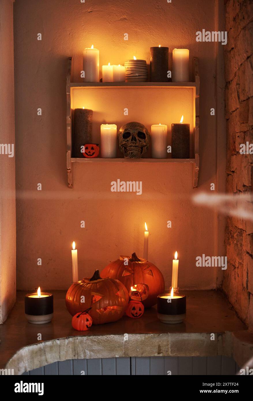 Créatif, décoration et vacances d'Halloween à la maison avec crâne effrayant, citrouille ou bougies. Effrayant, célébration et étagère dans la maison la nuit avec Banque D'Images