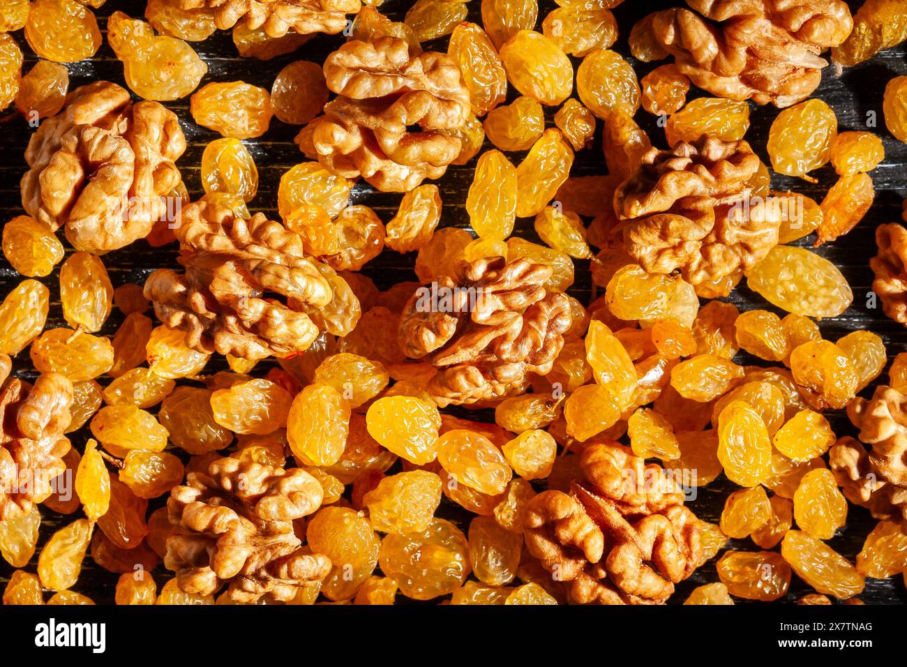 noix raisins secs sur fond de bois noir vue de dessus Banque D'Images