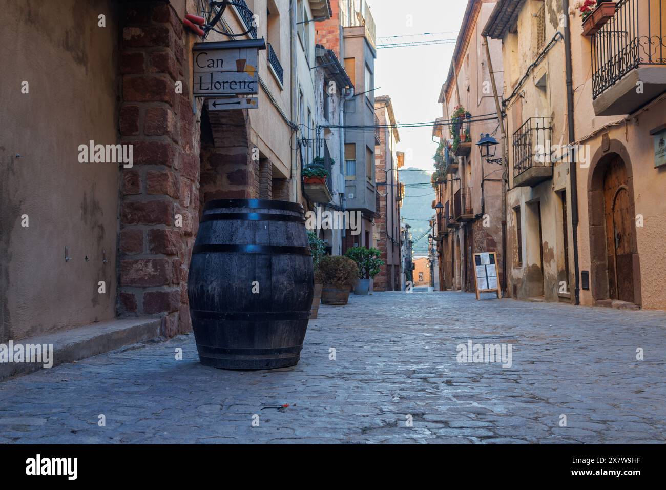 05-10-2024, Prades, Espagne : Rue avec pavés et un tonneau utilisé comme table dans la ville touristique de Prades Banque D'Images