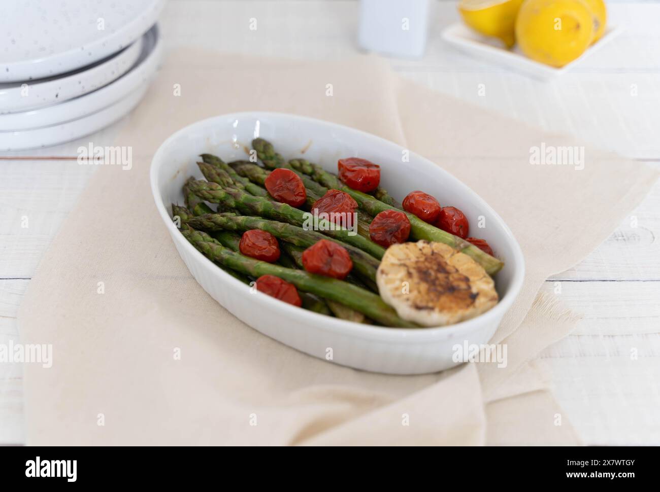 Représentant une source de grande fibre alimentaire les asperges vertes cuites dans un plat blanc et servies comme plat d'accompagnement prêt à manger. Banque D'Images