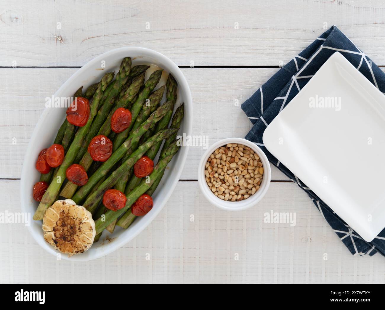 Asperges vertes cuites dans un plateau blanc et servies comme plat d'accompagnement prêt à manger. Représentant une source de grandes fibres alimentaires. Banque D'Images