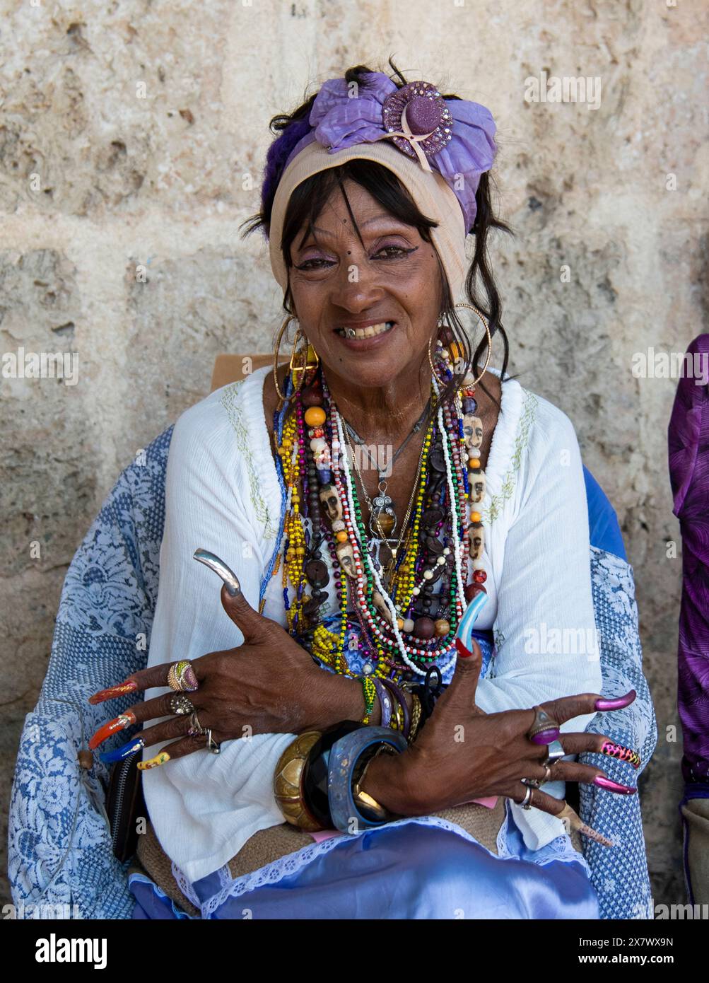 Femme cubaine avec des ongles très longs sourires montrant ses ongles longs et colorés. Banque D'Images