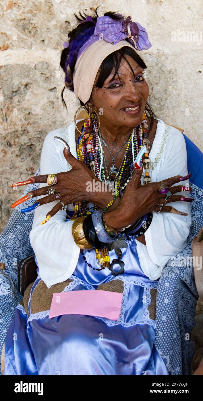 Femme cubaine avec des ongles très longs sourires montrant ses ongles longs et colorés. Banque D'Images