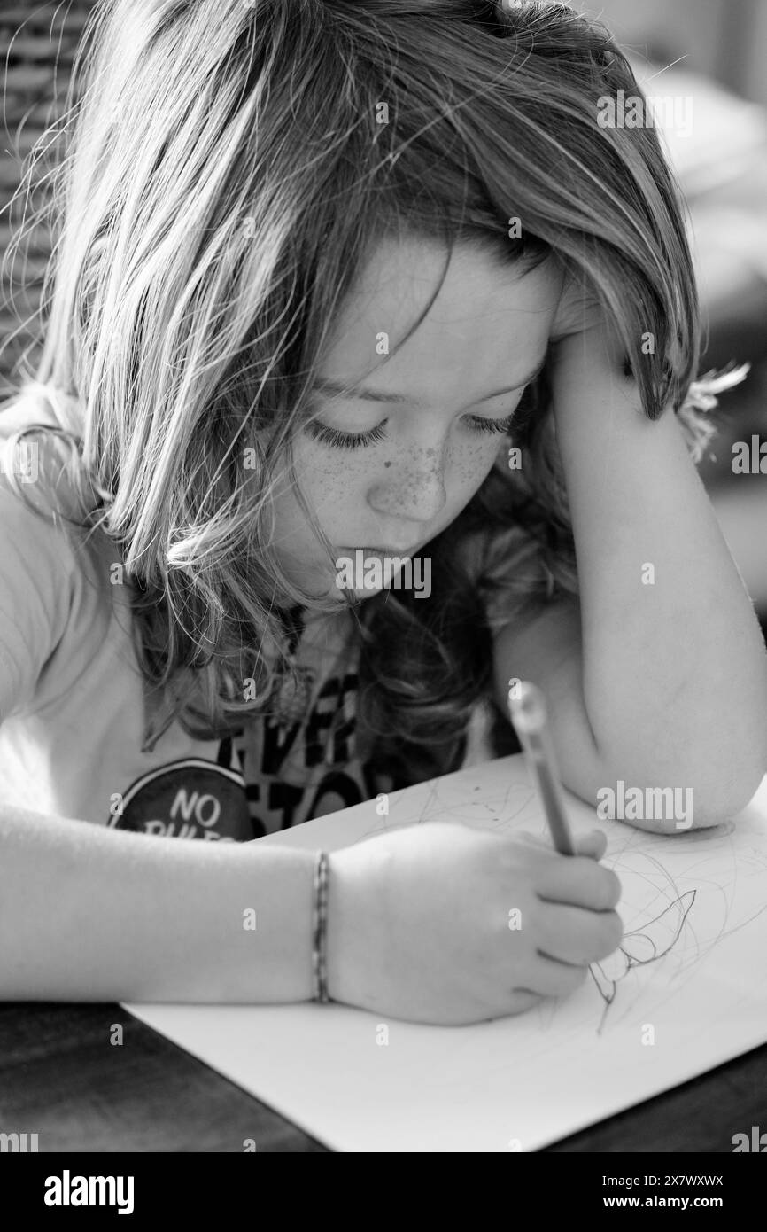 Italie, Sicile, Marina di Ragusa (Province de Ragusa) ; enfant mâle de 8 ans dessinant sur la table d'un salon dans un appartement privé Banque D'Images