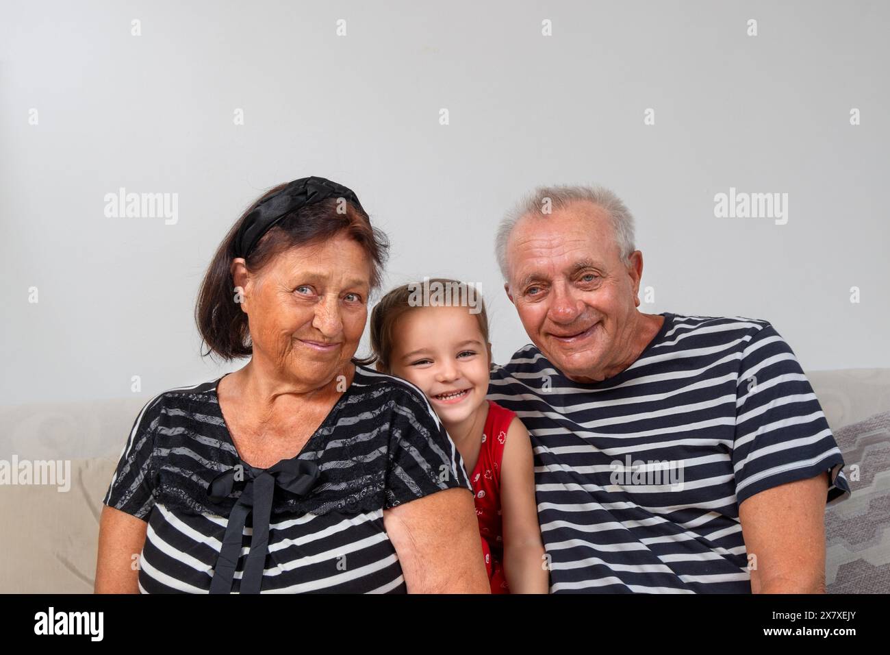 Portrait d'un aîné avec leur arrière-petite-fille sur le canapé Banque D'Images
