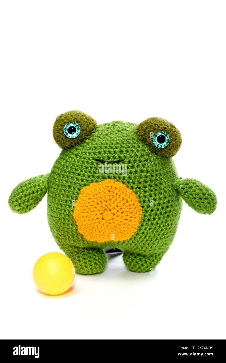 La grenouille est un jouet de laine tricoté doux fait de laine sur un fond blanc Banque D'Images