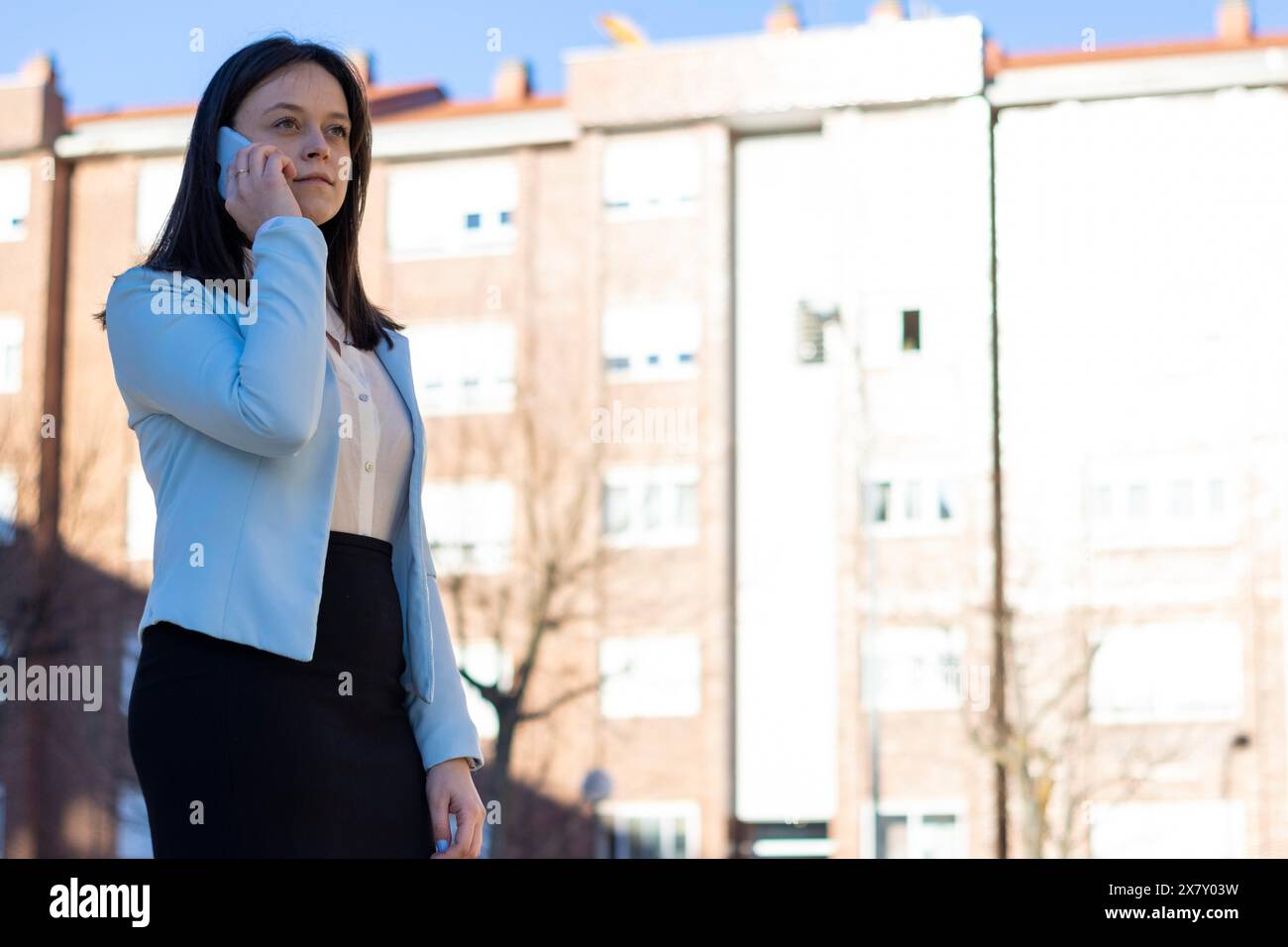 Portrait d'une jeune femme d'affaires caucasienne parlant au téléphone dans la rue Banque D'Images