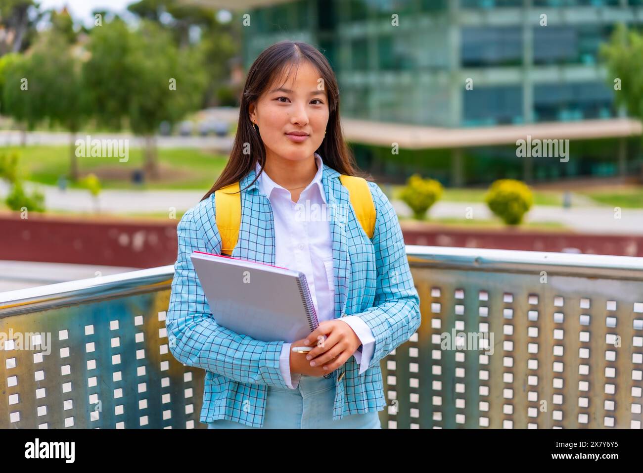 Portrait de trois quarts de longueur d'une étudiante asiatique de beauté debout fièrement à l'extérieur de l'université Banque D'Images