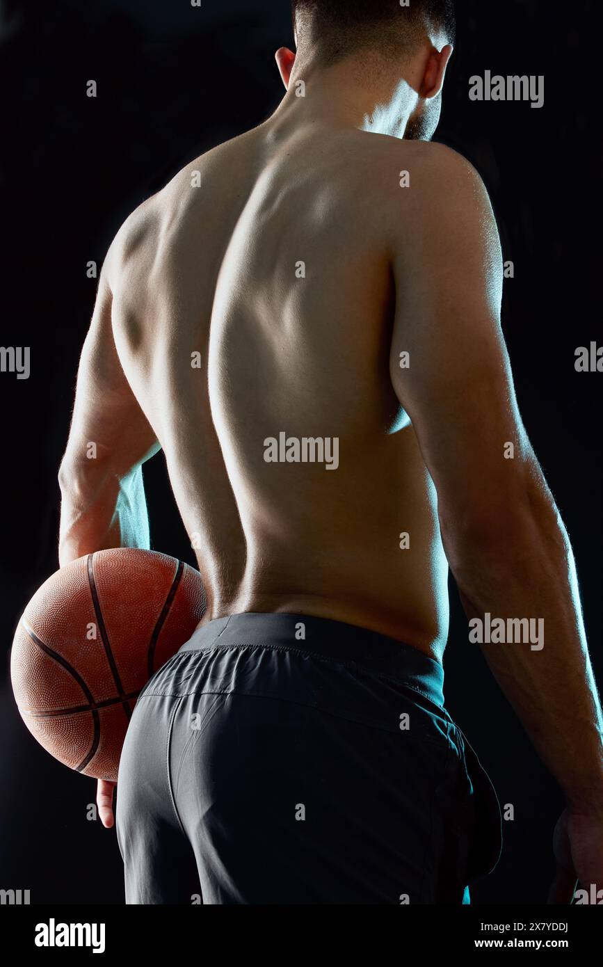 Homme, fitness et retour avec basket-ball pour le jeu de sport, match ou défi en studio sur un fond noir. Vue arrière d'une personne masculine, d'un athlète ou d'un joueur Banque D'Images