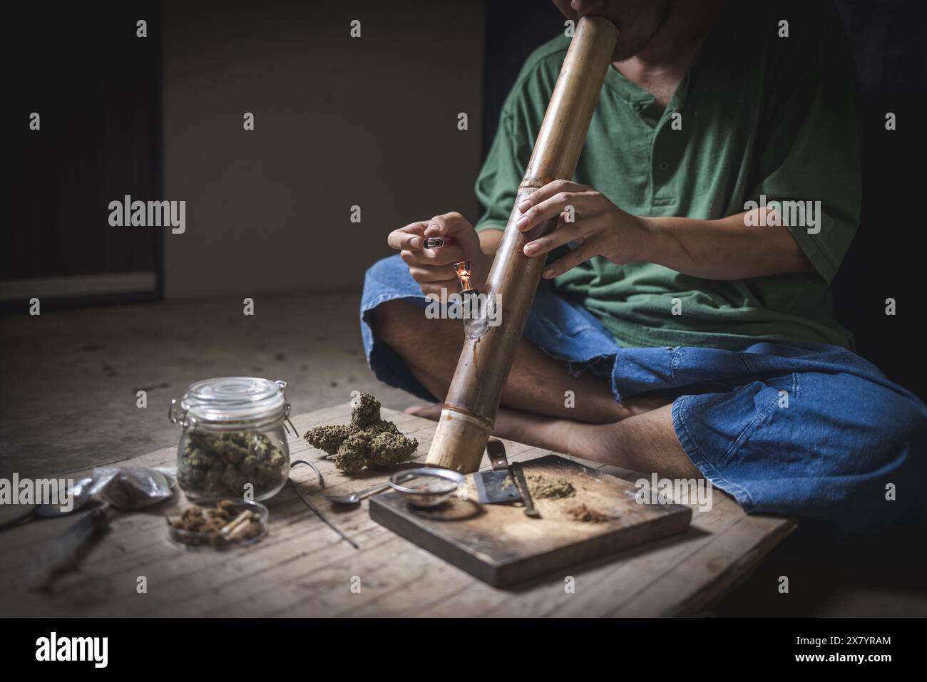 Un homme prépare la marijuana sur une planche à découper pour fumer, personne qui fume des drogues, toxicomane, toxicomane et concept de symptômes de sevrage. DroguesInte Banque D'Images