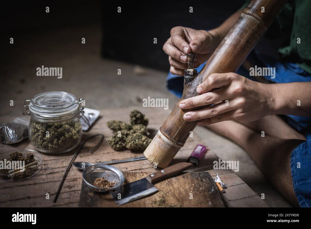 Un homme prépare la marijuana sur une planche à découper pour fumer, personne qui fume des drogues, toxicomane, toxicomane et concept de symptômes de sevrage. DroguesInte Banque D'Images