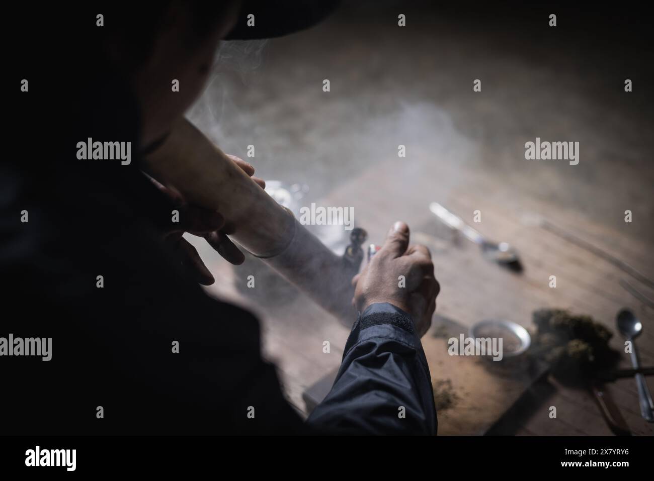 Un homme prépare la marijuana sur une planche à découper pour fumer, personne qui fume des drogues, toxicomane, toxicomane et concept de symptômes de sevrage. DroguesInte Banque D'Images