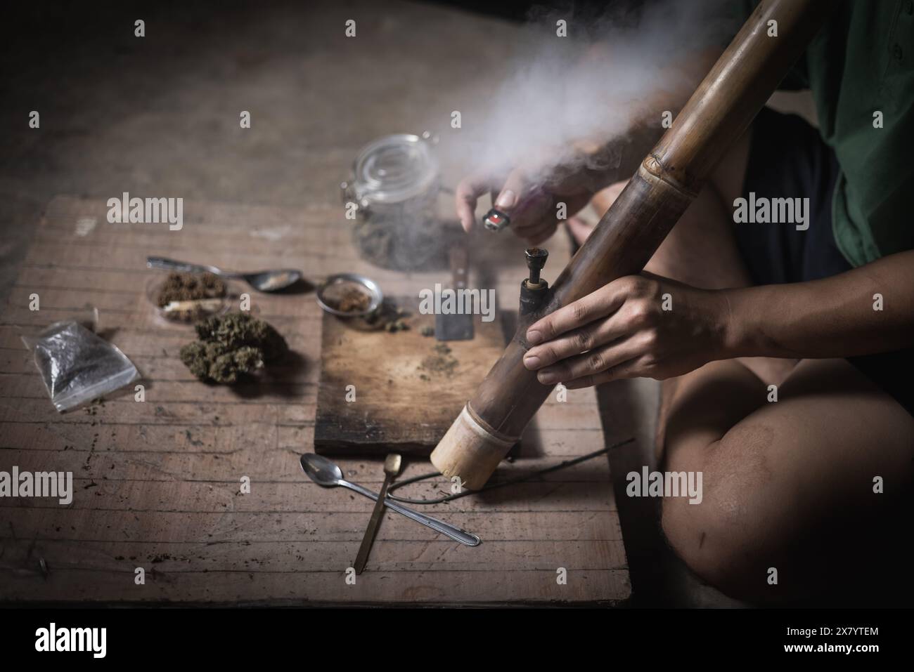 Un homme prépare la marijuana sur une planche à découper pour fumer, personne qui fume des drogues, toxicomane, toxicomane et concept de symptômes de sevrage. DroguesInte Banque D'Images