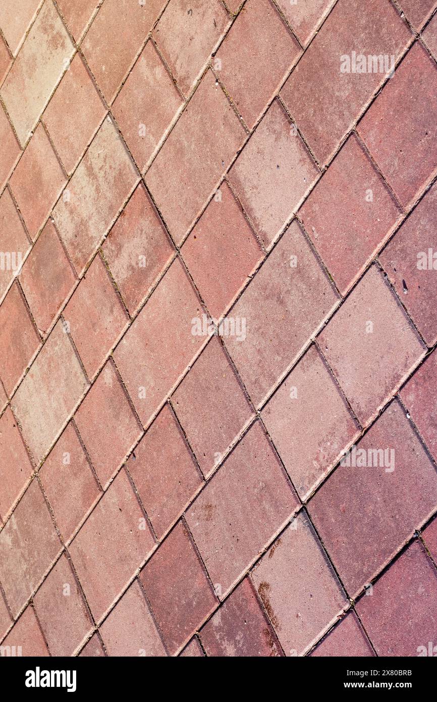 Une vue rapprochée d'un sol en briques rouges à motifs diagonaux, ressemblant à des briques brunes. Les formes rectangulaires créent un design de plancher unique Banque D'Images