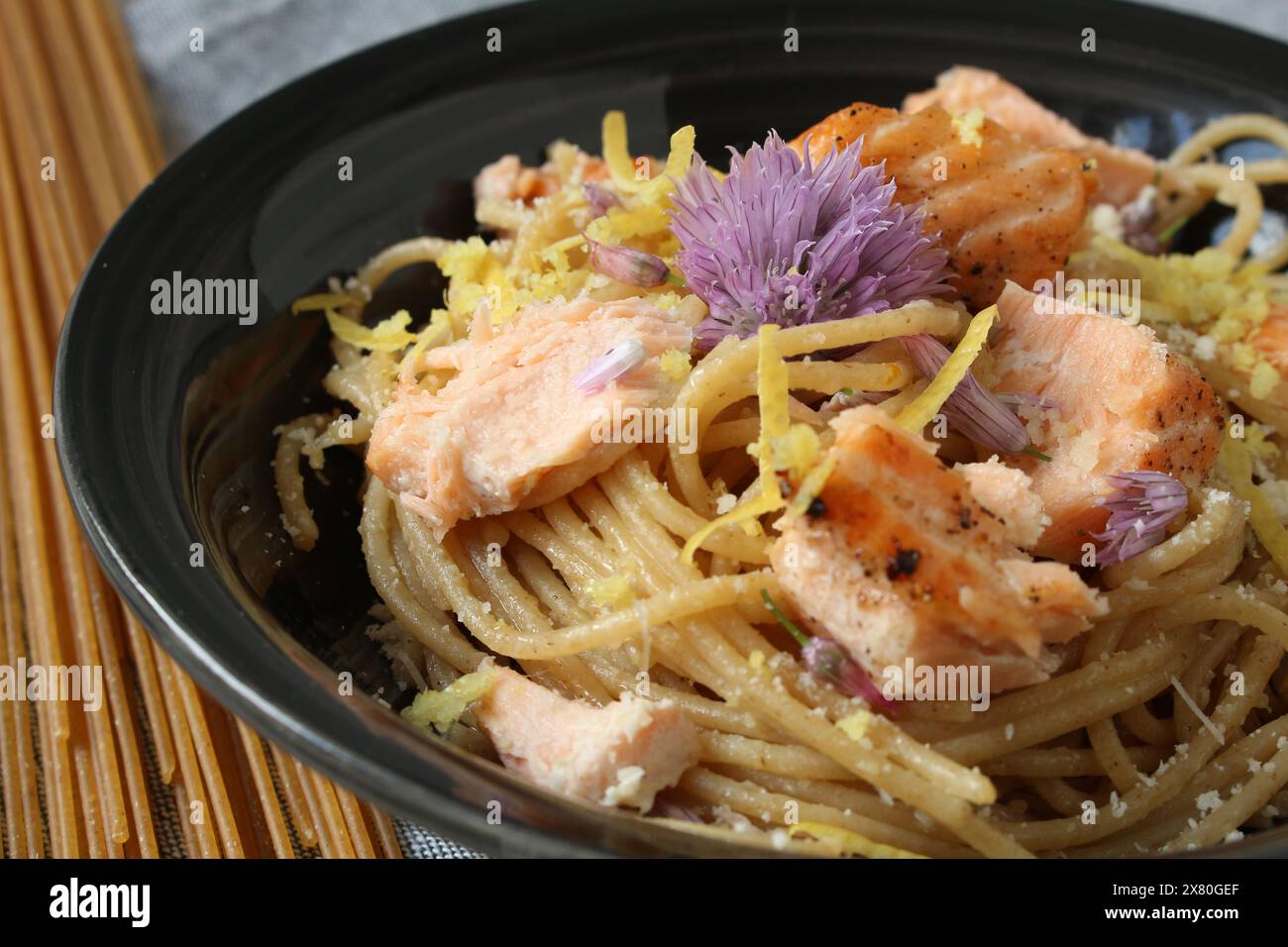 Pâtes au citron avec saumon et fleurs comestibles Banque D'Images