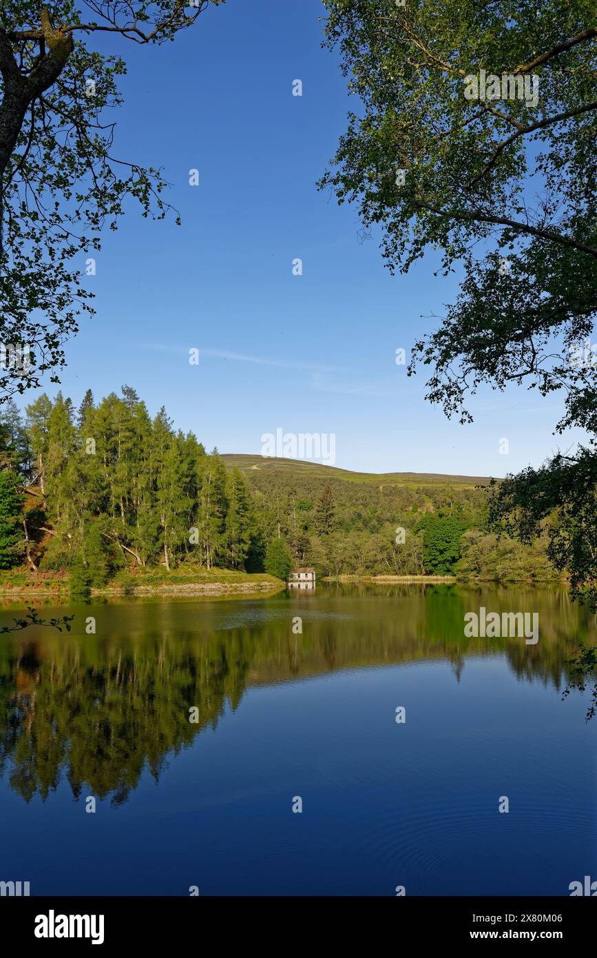 La vue vers l'ouest sur le réservoir Glen Ogil un tôt le matin sur le Wooden Boathouse sur les marges du lac. Banque D'Images