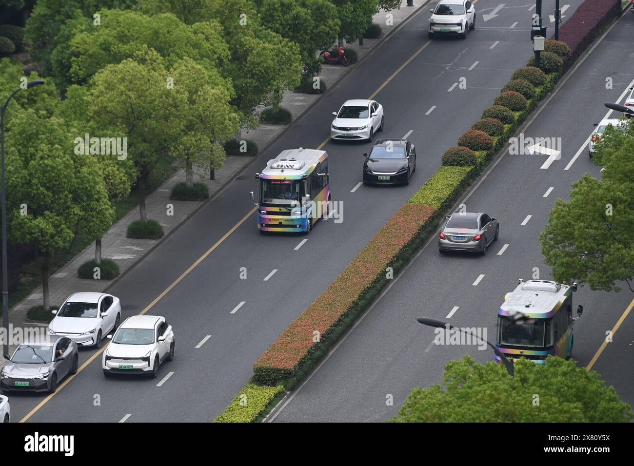 (240522) -- HANGZHOU, 22 mai 2024 (Xinhua) -- un minibus à conduite autonome circule sur une route dans le district de Yuhang, ville de Hangzhou, province du Zhejiang, dans l'est de la Chine, 22 mai 2024. La ligne de bus de conduite autonome dans le district de Yuhang est la première de son genre alimentée par la technologie de coordination véhicule-route à Hangzhou. Cette ligne de bus de 5 kilomètres serpente à travers les écoles, les parcs industriels, les complexes résidentiels et les stations de métro, gratuitement pour tous les citoyens. Les bus à conduite autonome réalisent une détection holographique du réseau routier grâce à des dispositifs de détection intelligents tels que des caméras haute définition et RA Banque D'Images