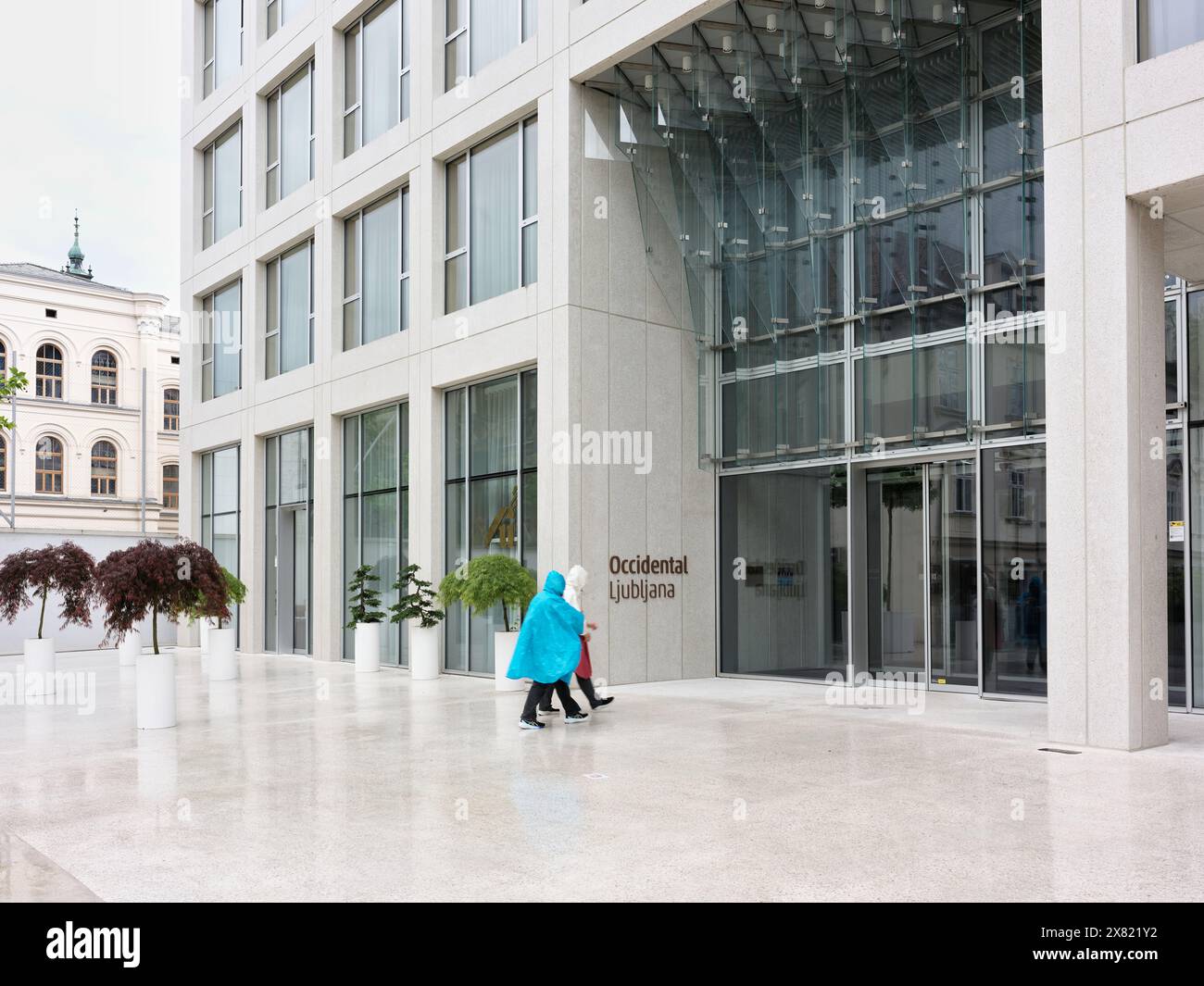 Un couple de touristes avec mac de pluie devant l'hôtel Occidental, Ljubljana, Slovénie, un jour de pluie. Banque D'Images