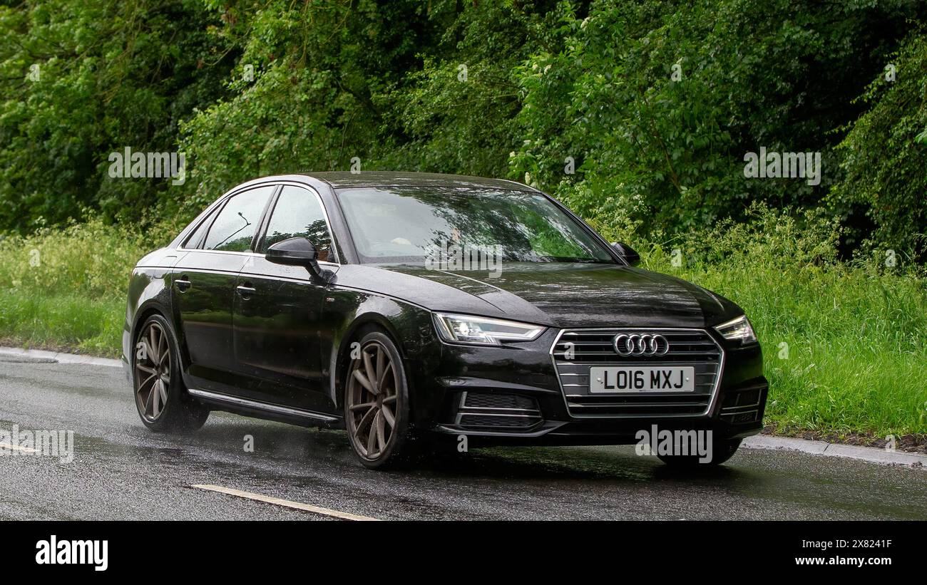 Stony Stratford, Royaume-Uni - 22 mai 2024 : 2016 voiture Audi A4 à moteur diesel noir conduisant sur une route britannique par un jour humide Banque D'Images