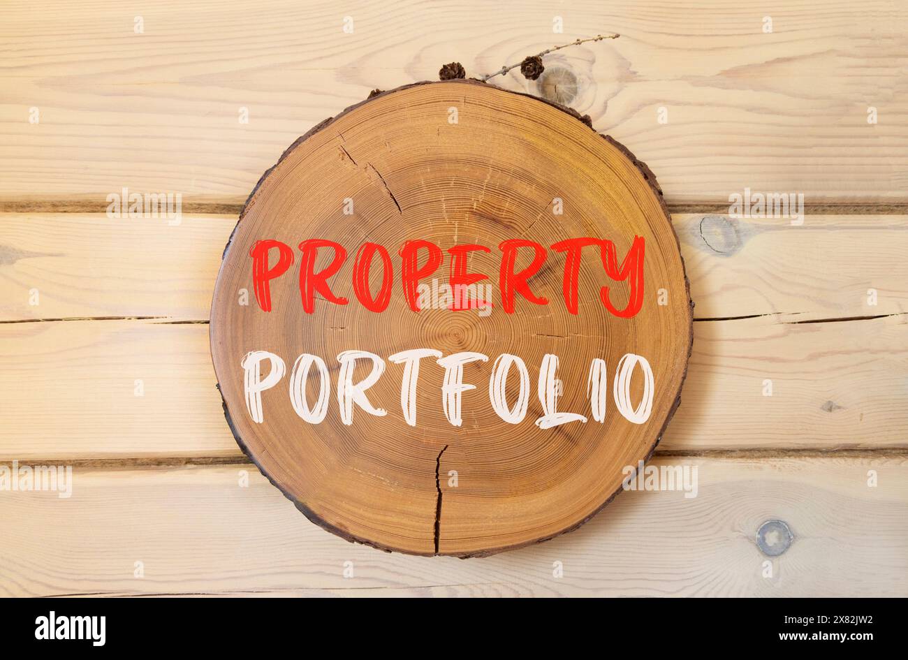 Symbole de portefeuille immobilier. Concept mots portefeuille de propriétés sur un beau cercle en bois. Beau fond de mur en bois. Portefeuille de biens d'entreprise Banque D'Images