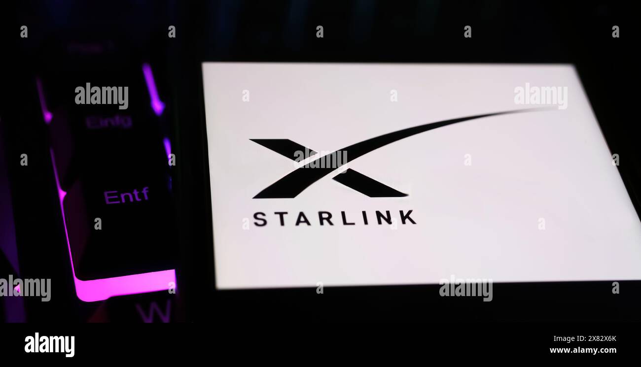 Viersen, Allemagne - 9 mai. 2024 : gros plan de smartphone avec lettrage logo de la constellation satellite Starlink sur clavier d'ordinateur Banque D'Images