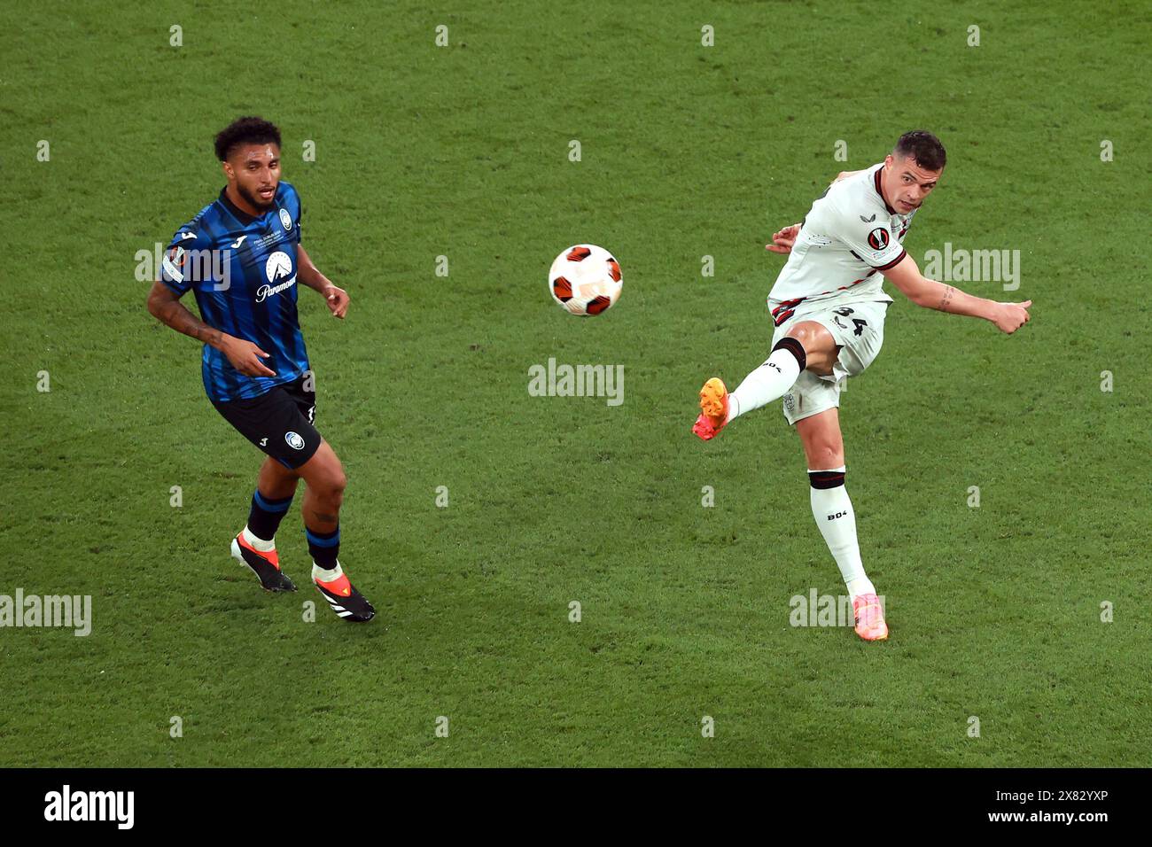 Granit Xhaka de Bayer Leverkusen (à droite) tente une croix vers le but lors de la finale de l'UEFA Europa League au stade Aviva de Dublin. Date de la photo : mercredi 22 mai 2024. Banque D'Images