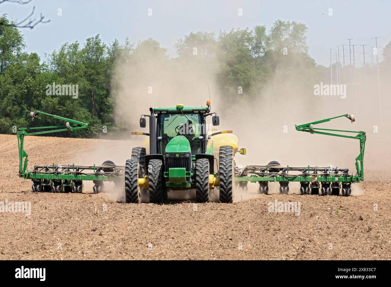 Albion, Michigan - Un nuage de poussière souffle derrière le tracteur alors qu'un agriculteur cultive son champ. Banque D'Images