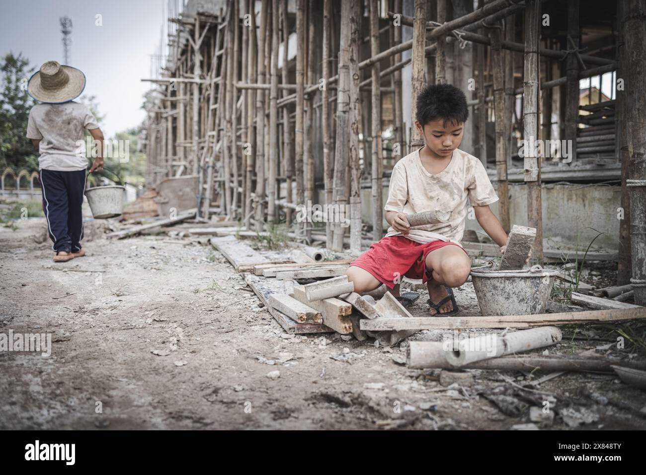 Deux enfants pauvres sont contraints de travailler dans le bâtiment. Enfants pauvres, pauvreté, travail des enfants, concept de Journée mondiale contre le travail des enfants. Banque D'Images