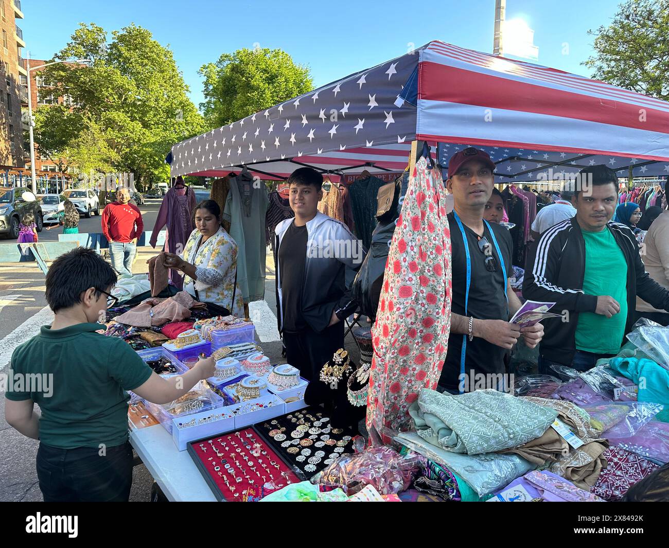 Vendeur vendant des bijoux et des vêtements à la foire de rue bangladaise dans le quartier de Kensington à Brooklyn, New York Banque D'Images