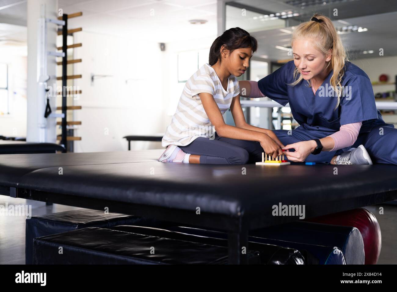 Au centre de réadaptation, une fille biraciale atteinte de paralysie cérébrale est assise, regardant la caméra Banque D'Images