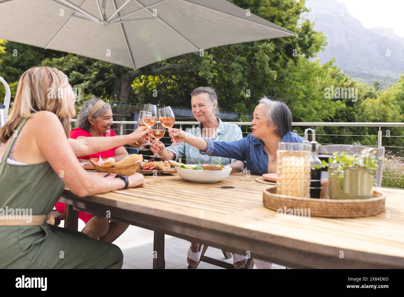 Diverses amies seniors grillant des verres à l'extérieur Banque D'Images