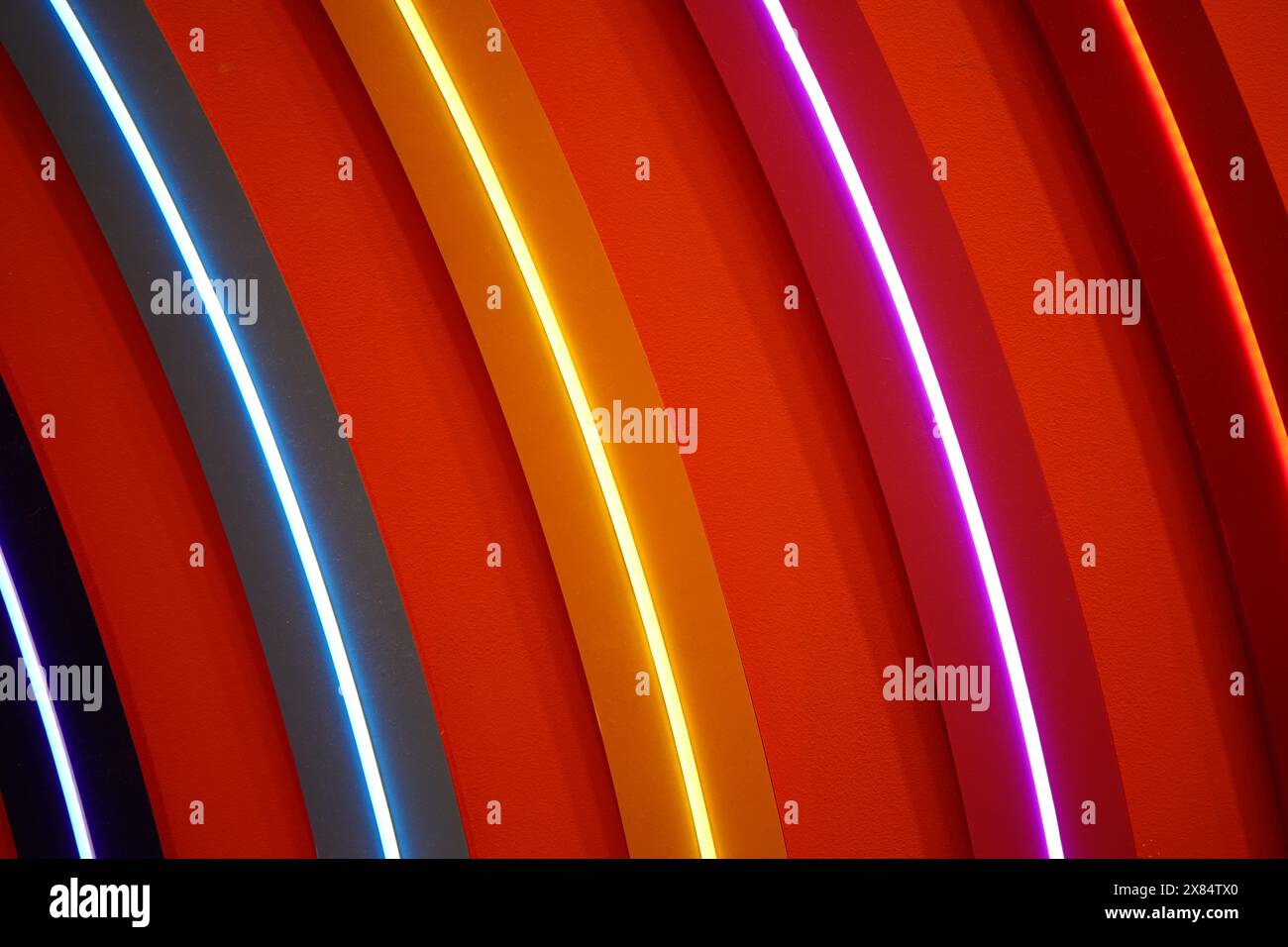 Cercles de néon en rouge, jaune et bleu sur fond rouge Banque D'Images