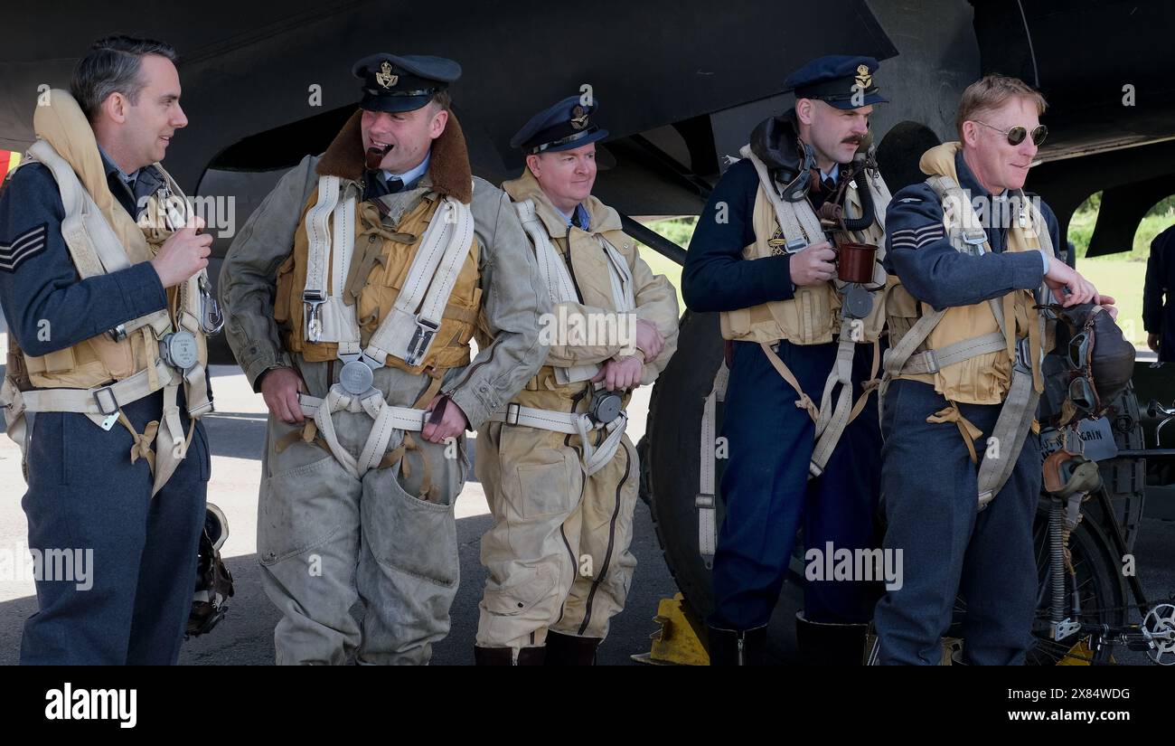 Réacteurs de deux équipages de la guerre mondiale devant un bombardier lourd quatre moteurs Halifax britannique au musée de l'air d'Elvington. Yorkshire. ROYAUME-UNI. Banque D'Images