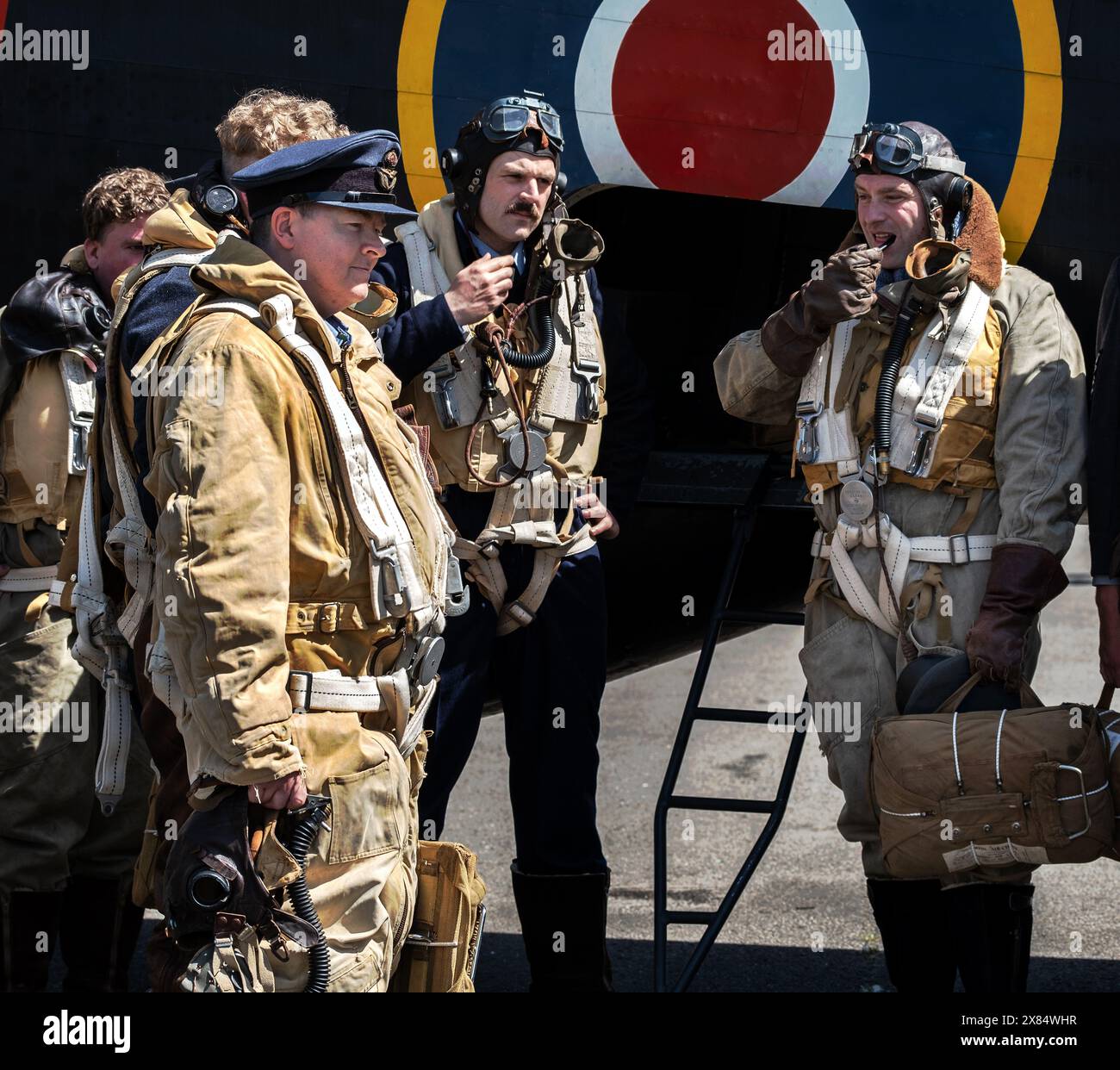 Réacteurs de deux équipages de la guerre mondiale devant un bombardier lourd quatre moteurs Halifax britannique au musée de l'air d'Elvington. Yorkshire. ROYAUME-UNI. Banque D'Images