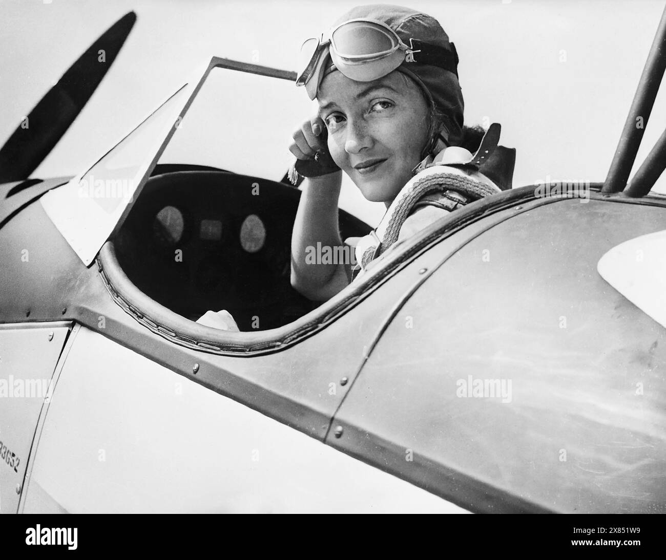 Nancy Harkness Love, 28 ans, directrice de l'escadron de ferries auxiliaires féminines des États-Unis, ajuste son casque dans le cockpit d'un Fairchild PT-19, un avion de l'armée, avant de décoller d'une base de l'est des États-Unis. Les femmes sous son commandement transporteront des avions des usines aux aéroports côtiers, d'où ils seront transportés vers les fronts de bataille outre-mer. Entre 1942 et 1945. Banque D'Images